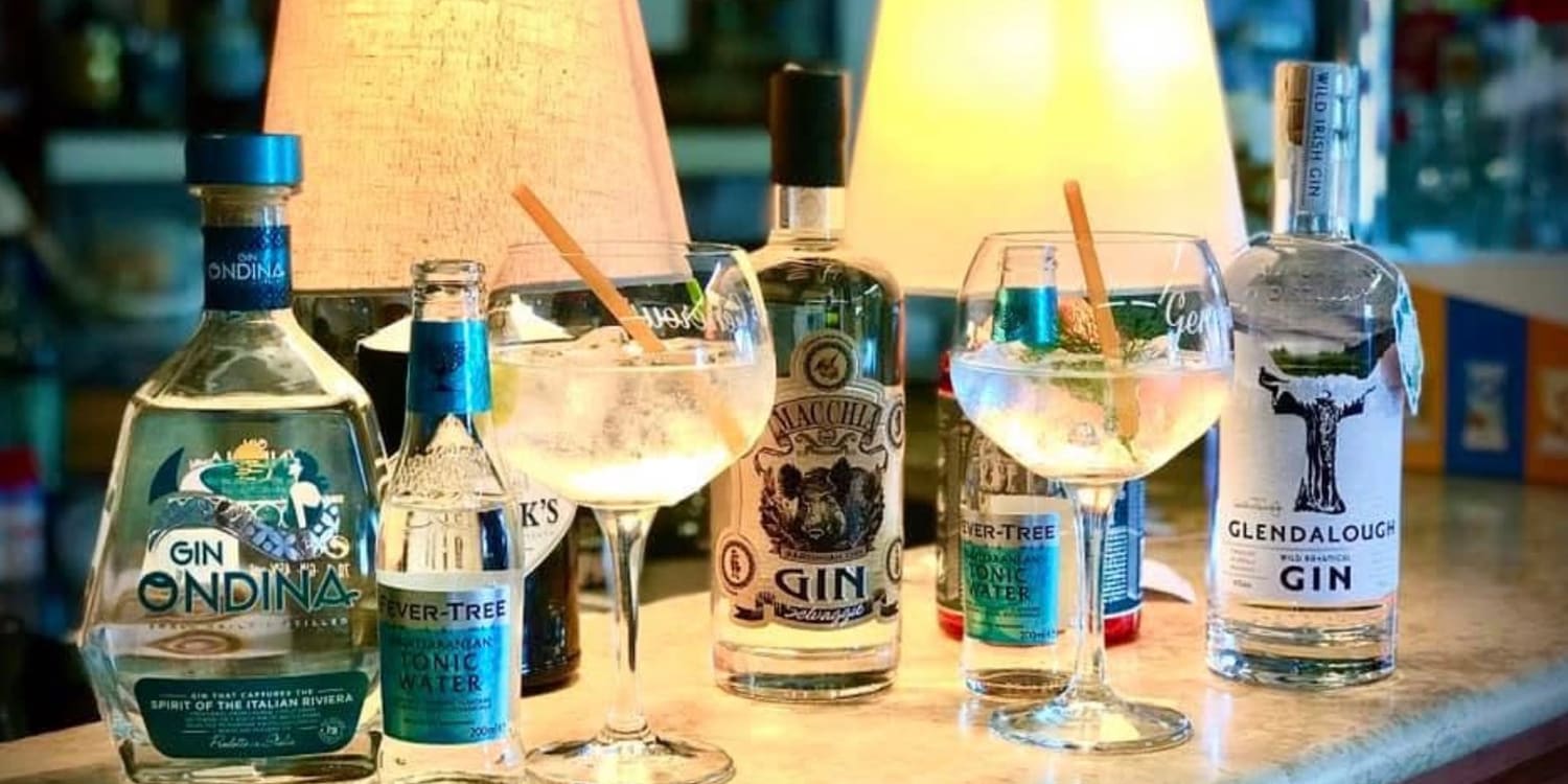 Il banco del Bar Centrale la sera: le bottiglie di gin allineate sotto le lampade accese, con due gin tonic pronti da servire